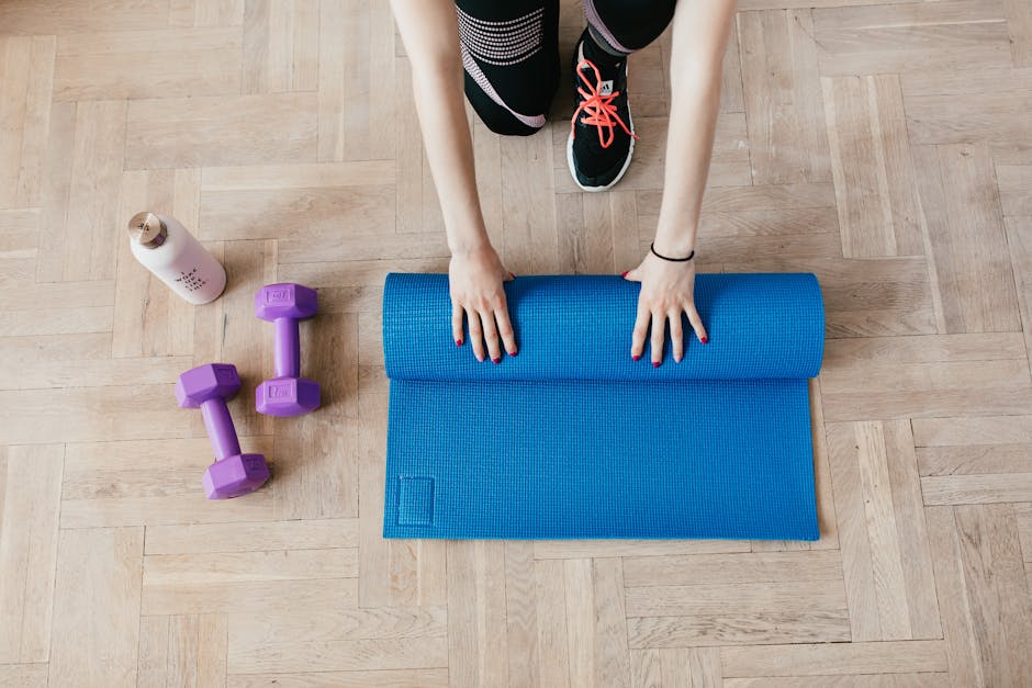 Yoga mat and water bottle on a wooden floor